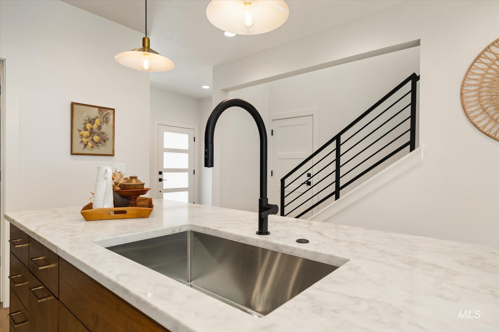 5612 West Grover Street Boise, ID 83705 - Photo 20 of 50 Kitchen featuring light stone countertops, decorative light fixtures, dark brown cabinetry, and recessed lighting