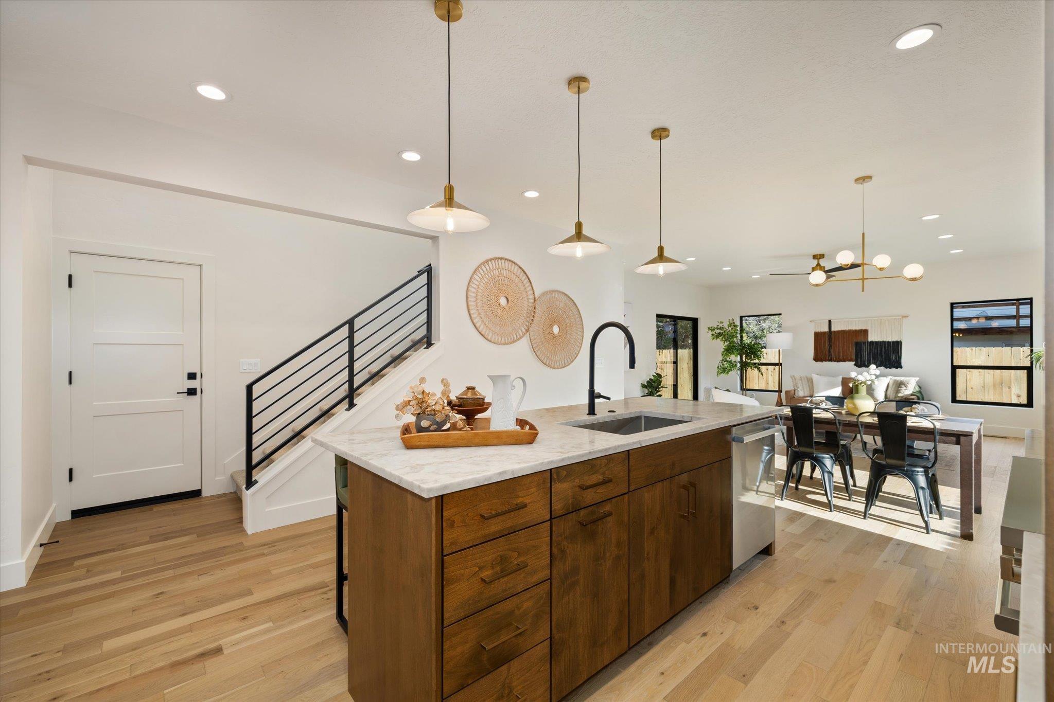 5612 West Grover Street Boise, ID 83705 - Photo 21 of 50 Kitchen featuring light stone countertops, pendant lighting, an island with sink, light wood-style floors, and recessed lighting