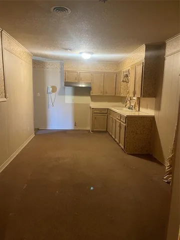 a view of a kitchen with a sink and dishwasher with wooden floor