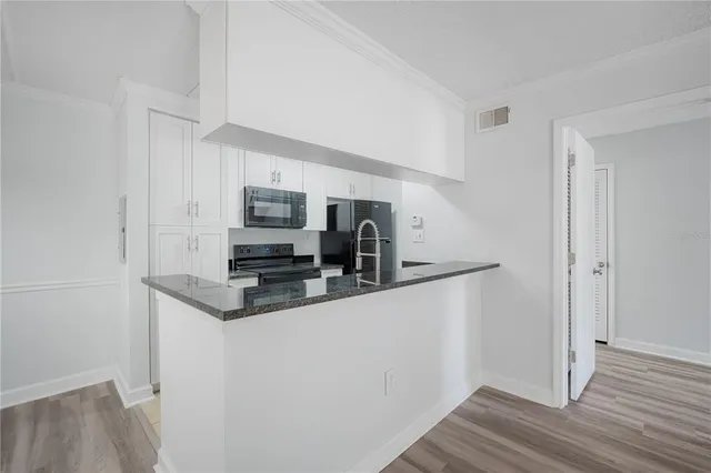 a kitchen with stainless steel appliances granite countertop a refrigerator and a stove top oven