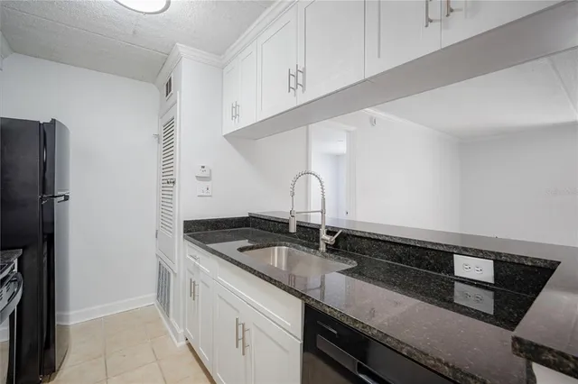 a kitchen with granite countertop a sink and cabinets