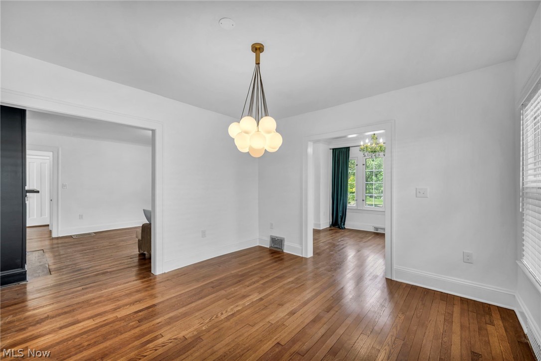 2135 Coventry Road, Unit DOWN Cleveland, OH 44118 - Photo 9 of 34 Unfurnished dining area featuring dark wood-style flooring and a chandelier