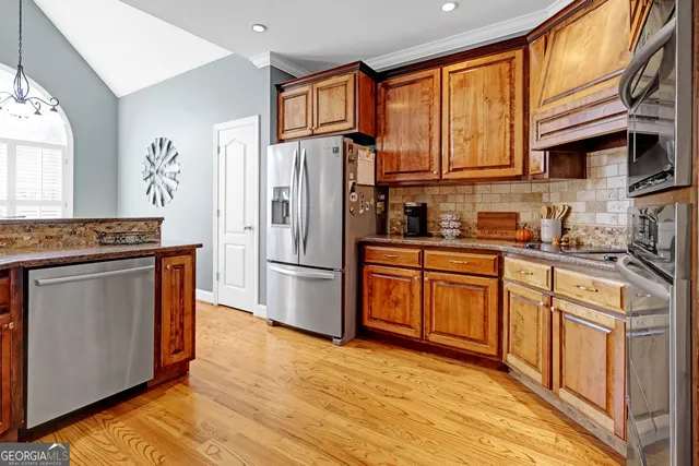 a kitchen with stainless steel appliances granite countertop a refrigerator stove top oven and sink