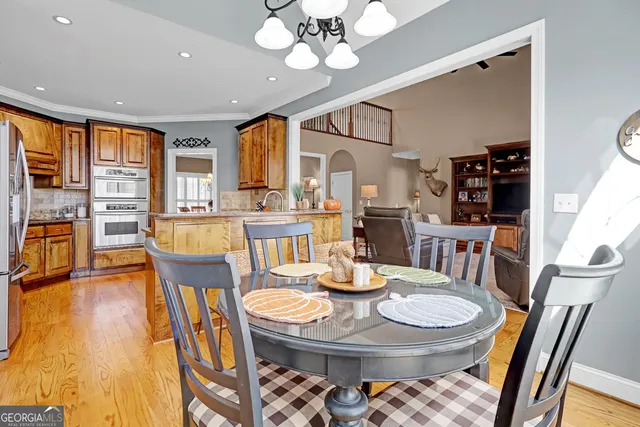 a dining room with furniture a chandelier and wooden floor
