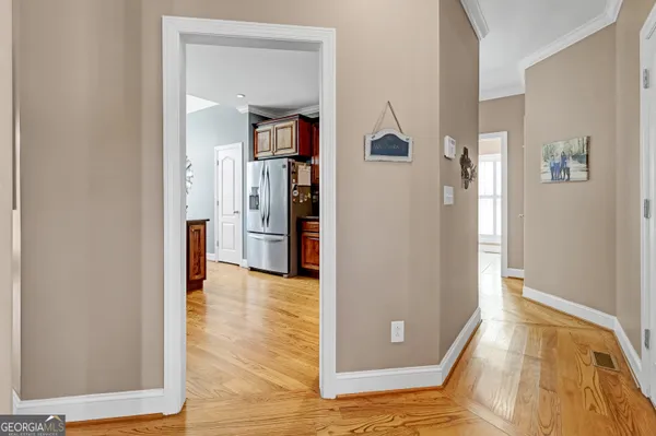 a view of a hallway with wooden floor and a living room