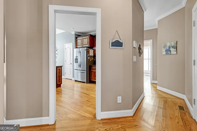 a view of a hallway with wooden floor and a living room