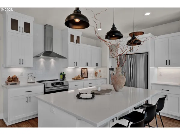 a kitchen with stainless steel appliances a table chairs and a refrigerator