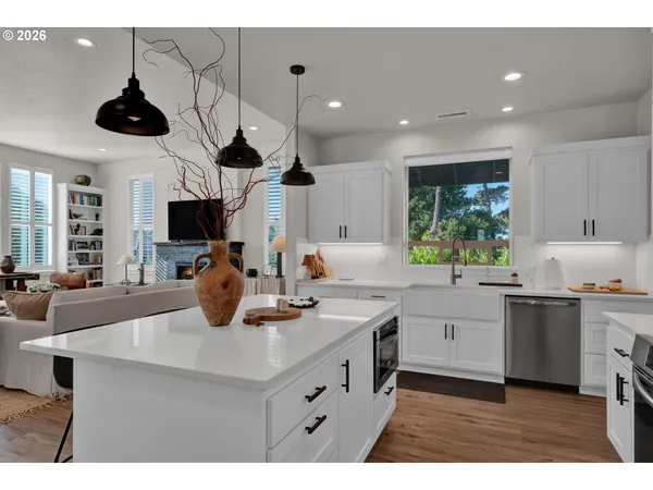 a kitchen with a sink a center island stainless steel appliances and cabinets