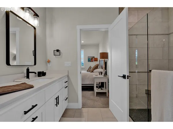a en suite bathroom with a double vanity sink a mirror and shower