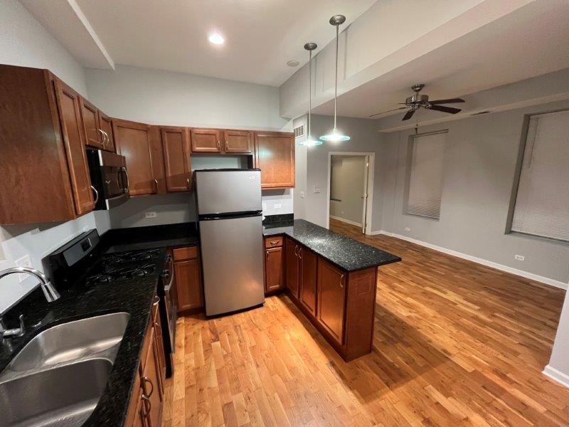 2249 South Bell Avenue, Unit 1R Chicago, IL 60608 - Photo 4 of 11 a kitchen with stainless steel appliances granite countertop a refrigerator a stove and a sink