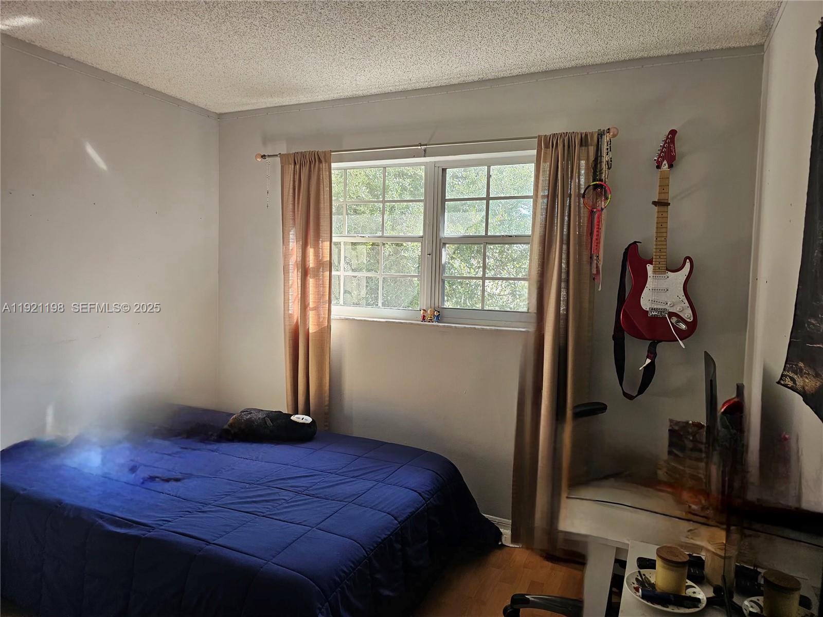 10816 Southwest 75th Street Miami, FL 33173 - Photo 11 of 20 a bedroom with a bed and wooden floor