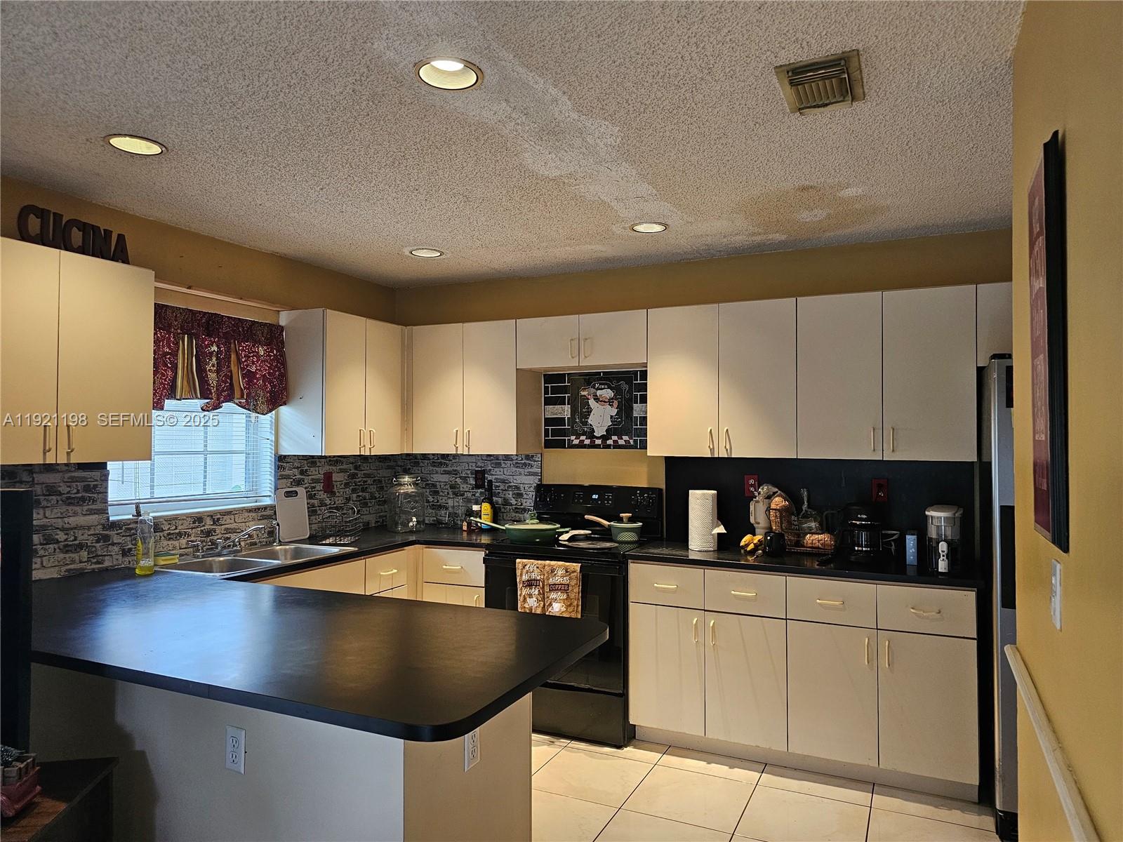 10816 Southwest 75th Street Miami, FL 33173 - Photo 6 of 20 a kitchen with stainless steel appliances granite countertop a sink a stove and a refrigerator