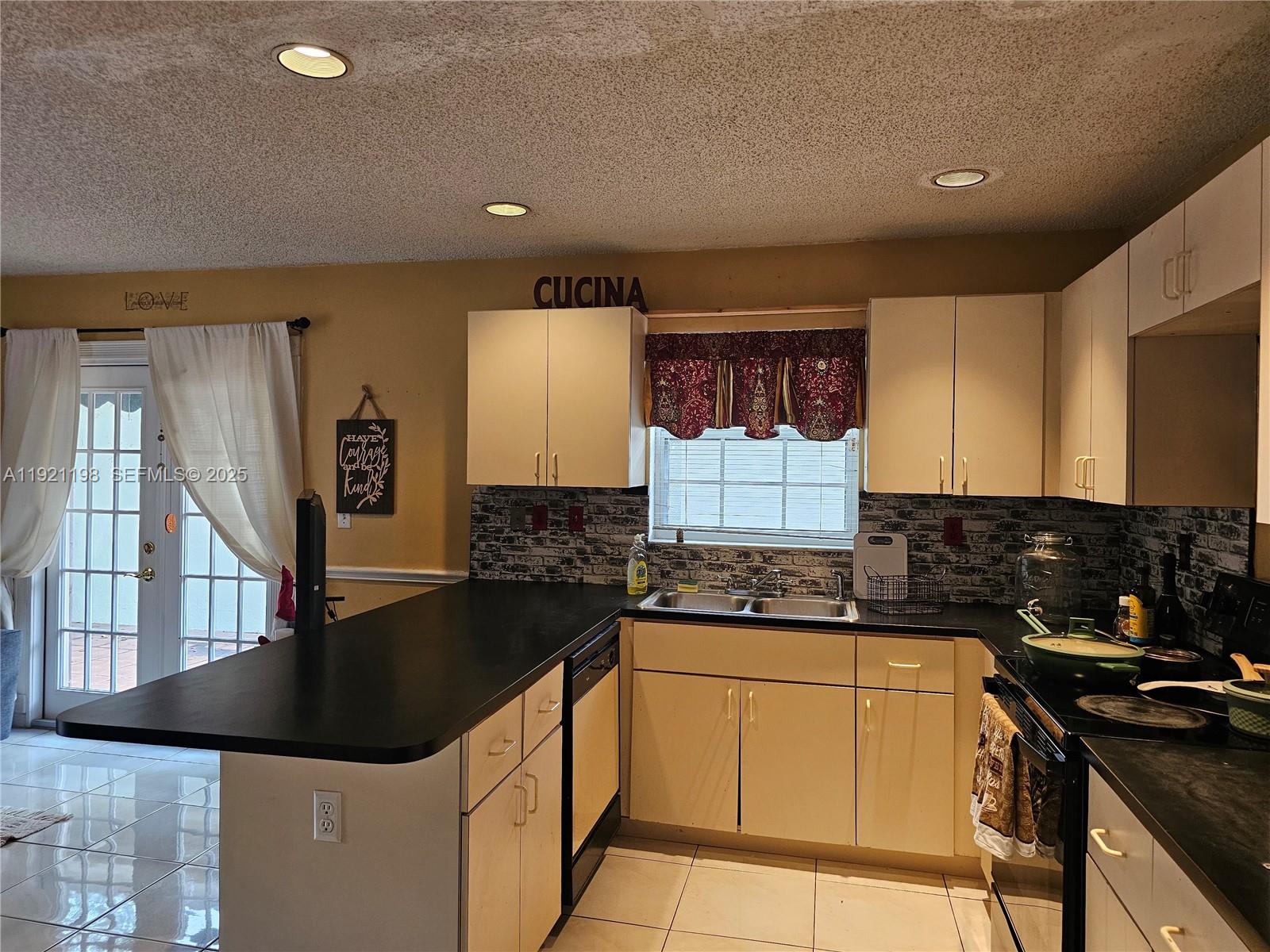 10816 Southwest 75th Street Miami, FL 33173 - Photo 7 of 20 a kitchen with granite countertop a sink a stove and cabinets