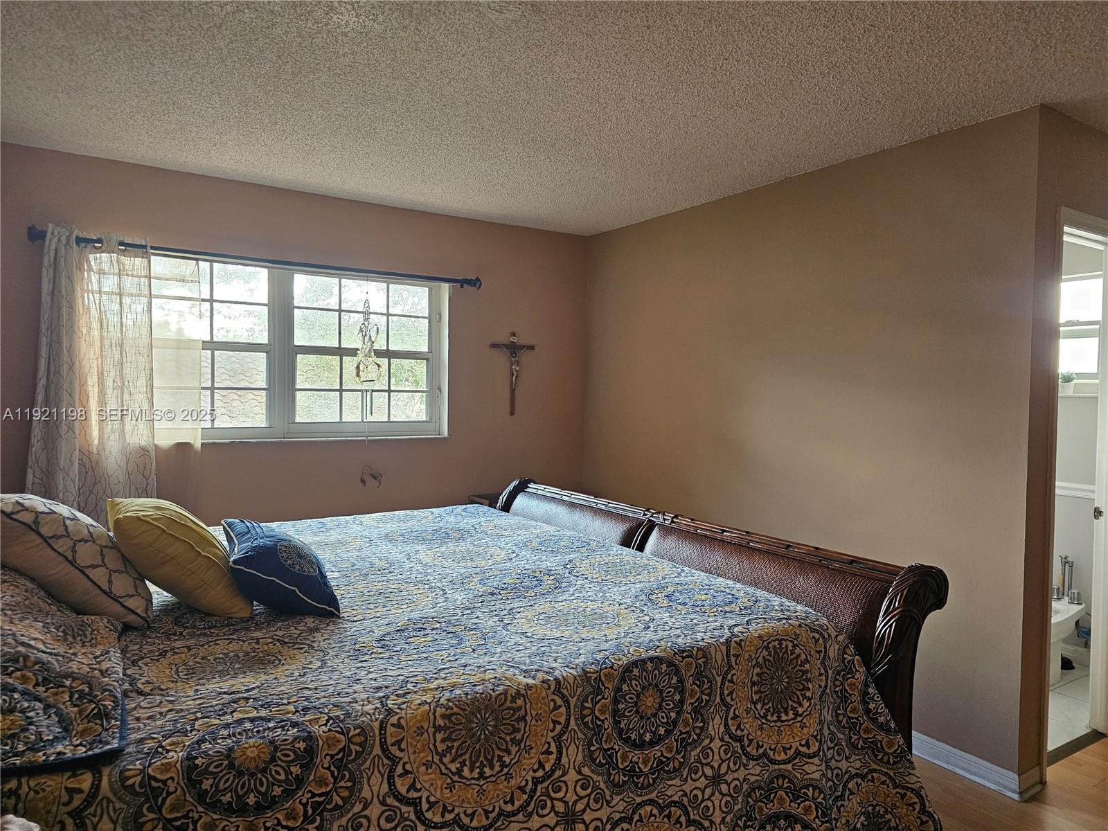 10816 Southwest 75th Street Miami, FL 33173 - Photo 10 of 20 a bedroom with a bed and wooden floor