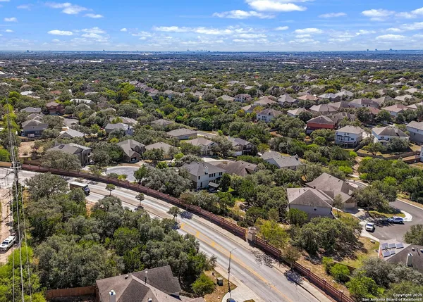 an aerial view of residential houses with outdoor space and trees