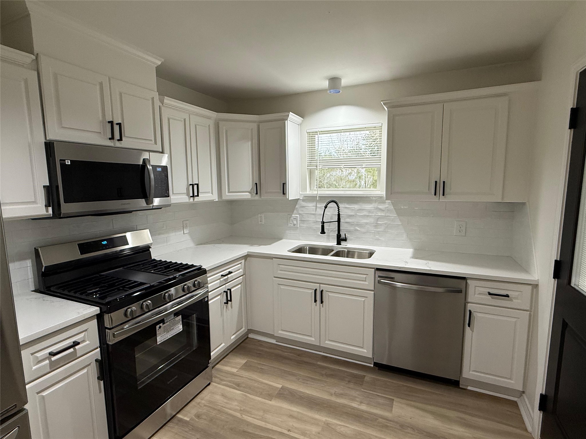 6210 Delany Road Hitchcock, TX 77563 - Photo 5 of 12 a kitchen with cabinets appliances a sink and a window