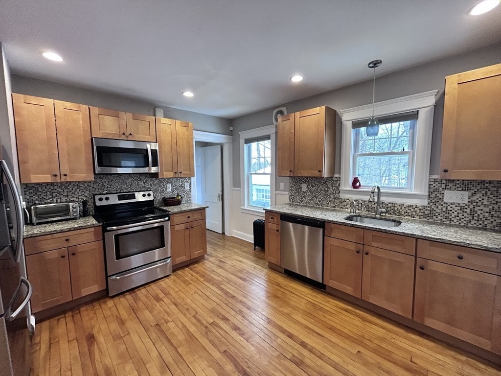 17 Longfellow Road Worcester, MA 01602 - Photo 2 of 19 a kitchen with granite countertop a stove a sink and a microwave