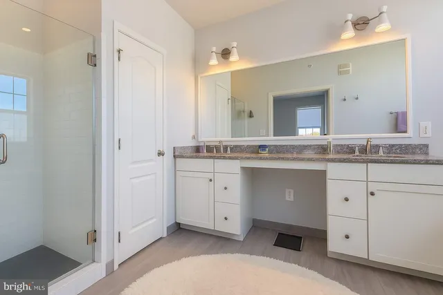 a spacious bathroom with a granite countertop sink and a mirror