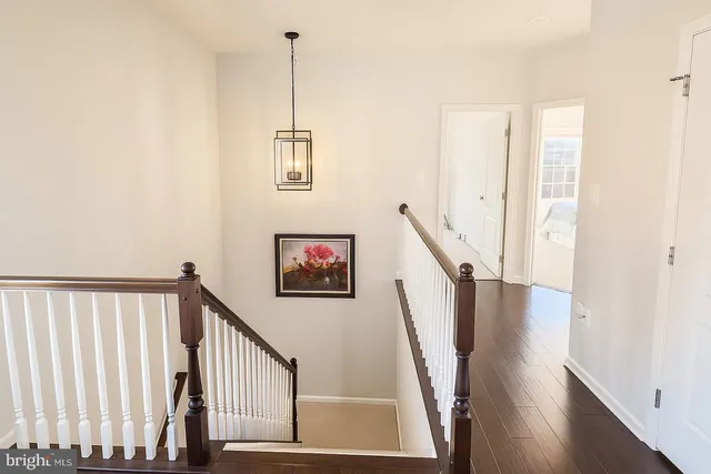 a view of a hallway with wooden floor and stairs