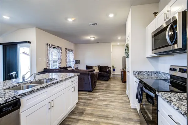 a kitchen with stainless steel appliances granite countertop a stove and a sink
