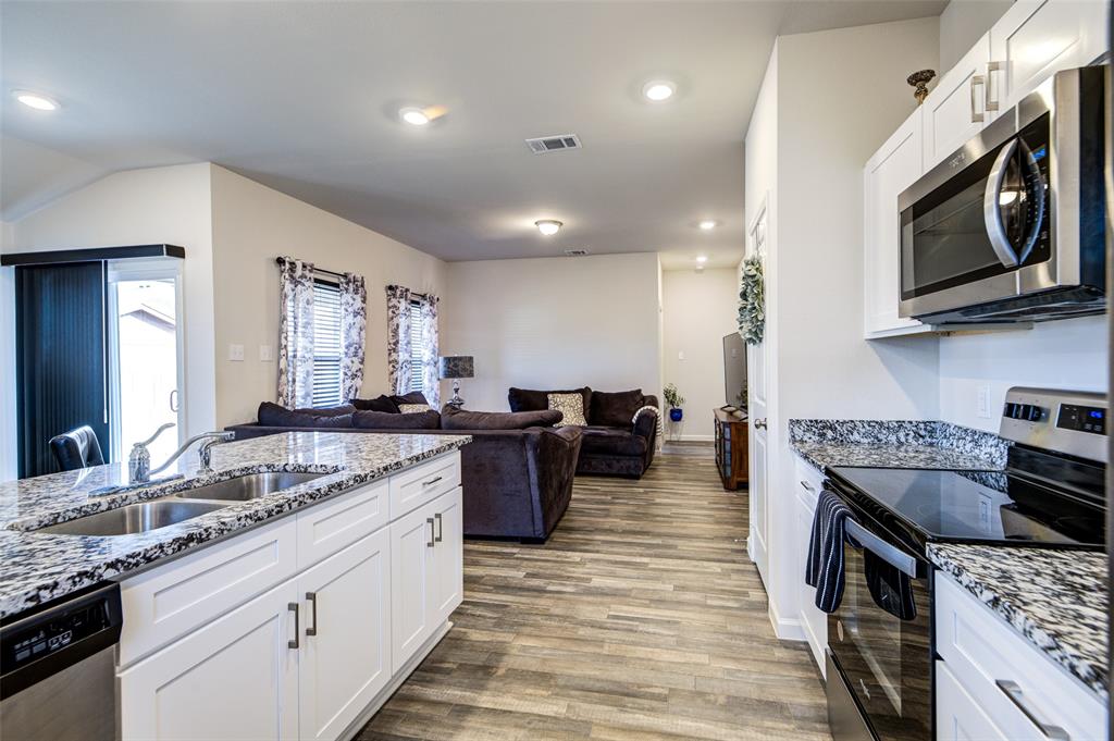 905 Avagail Avenue Springtown, TX 76082 - Photo 11 of 26 Kitchen with stainless steel appliances, white cabinets, dark stone counters, and recessed lighting