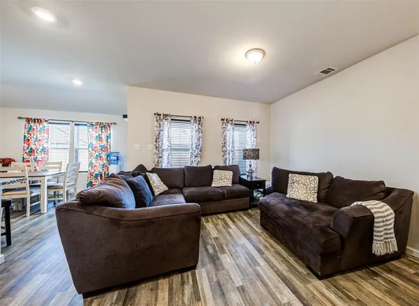 a living room with furniture and a wooden floor