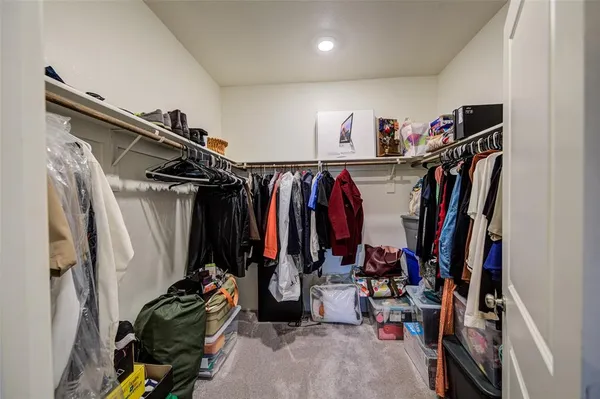 a view of walk in closet with clothes
