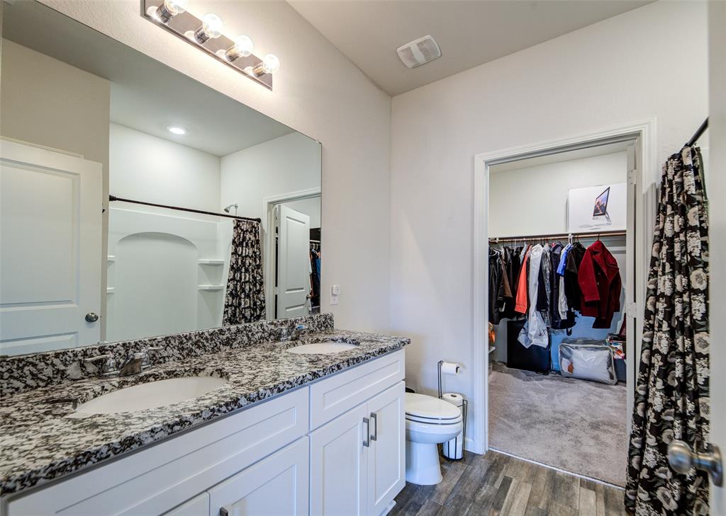 905 Avagail Avenue Springtown, TX 76082 - Photo 22 of 26 Bathroom featuring a walk in closet, double vanity, a shower with shower curtain, and dark wood-style floors