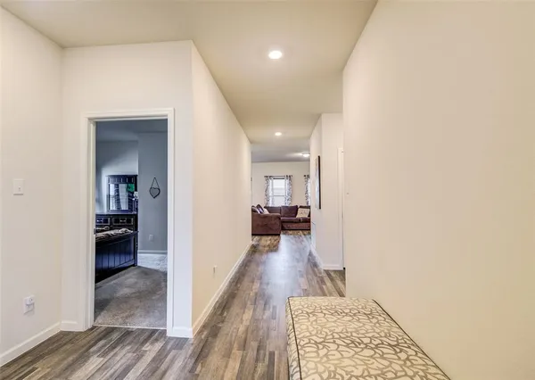 a view of a hallway with wooden floor and a living room