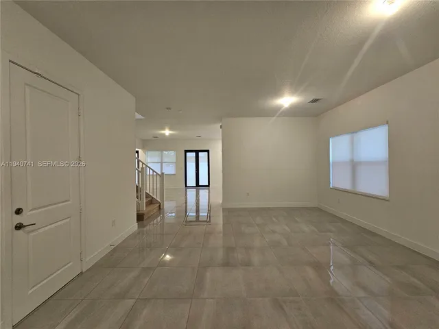 a large white kitchen with a large window and kitchen view