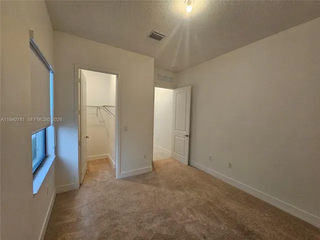 a view of hallway with a sink and a mirror