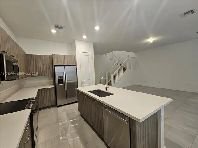 a kitchen with a sink a refrigerator and a stove