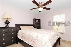a bedroom with a bed and a lamp on dresser