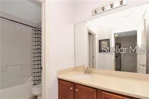 a bathroom with a granite countertop sink a mirror and a bathtub