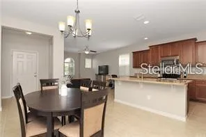 a view of a dining room and livingroom with furniture a chandelier and wooden floor