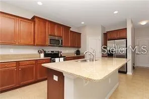 a kitchen with stainless steel appliances granite countertop a sink a stove and a microwave