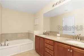 a bathroom with a granite countertop sink and a bathtub