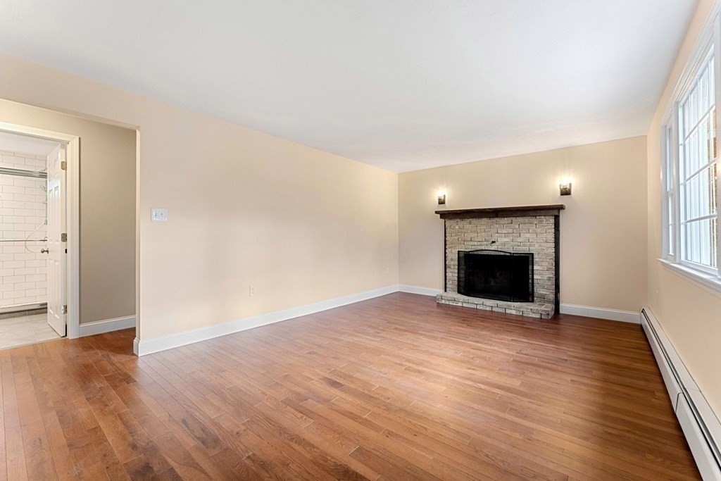1069 Main Street Dunstable, MA 01827 - Photo 19 of 41 an empty room with wooden floor and a fireplace