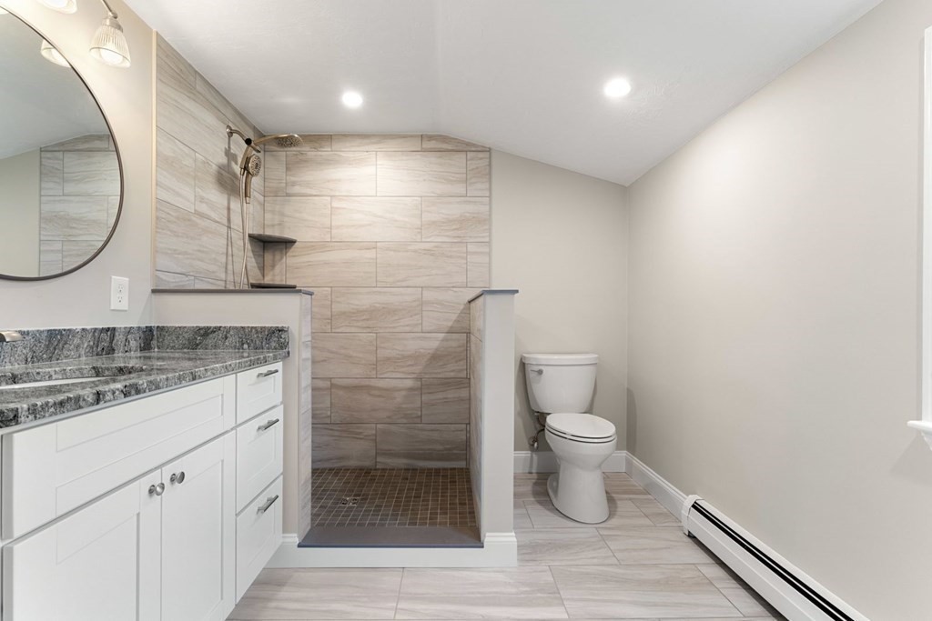 1069 Main Street Dunstable, MA 01827 - Photo 25 of 41 a bathroom with a granite countertop sink a toilet and a mirror