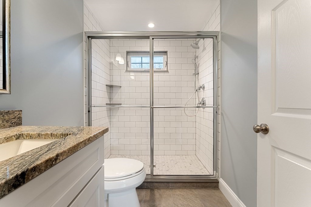 1069 Main Street Dunstable, MA 01827 - Photo 30 of 41 a bathroom with a granite countertop sink toilet and shower