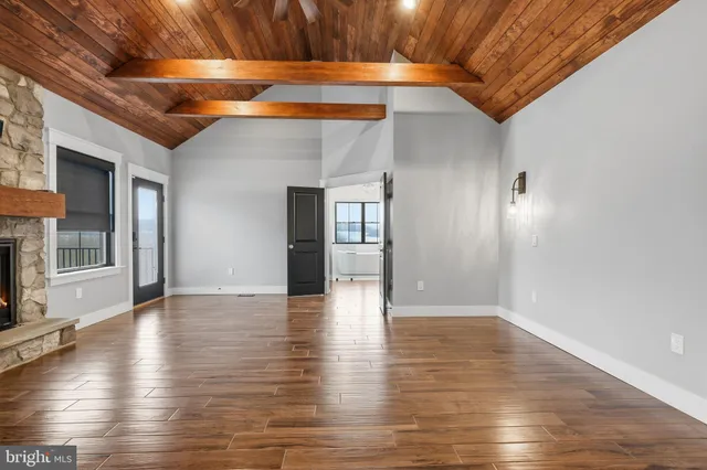 a view of an empty room with a window and fireplace