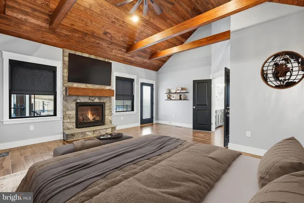 a view of an empty room with wooden floor fireplace and a window