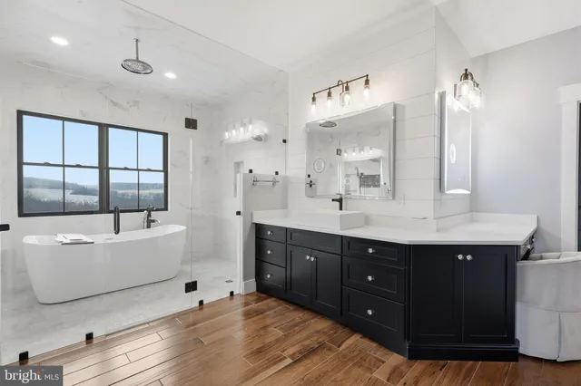 a kitchen with stainless steel appliances kitchen island granite countertop a stove a sink and a large refrigerator with wooden floor