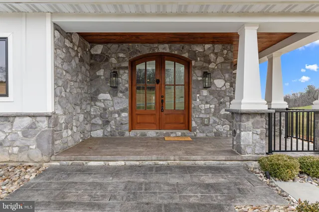 a view of an empty room with wooden floor and a fireplace
