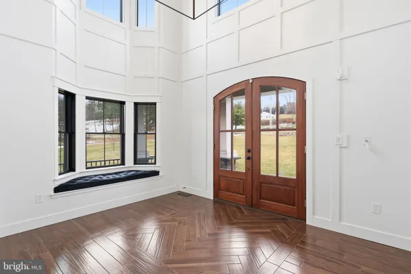 a view of an empty room with wooden floor fireplace and a window
