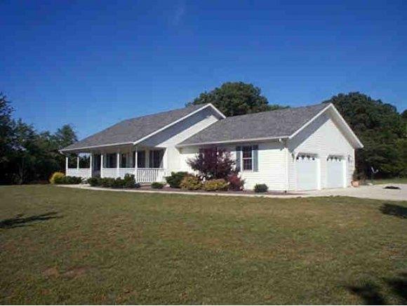 a view of a house with a big yard and large trees