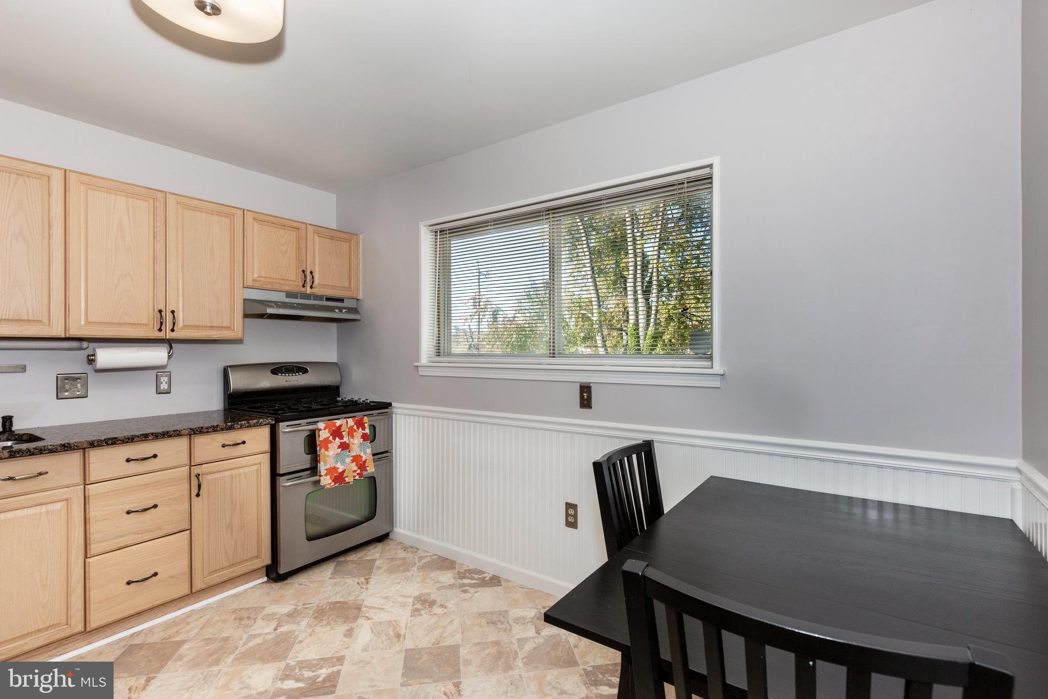 318 Bryanstone Road Reisterstown, MD 21136 - Photo 6 of 36 a kitchen with granite countertop a stove a sink and a microwave