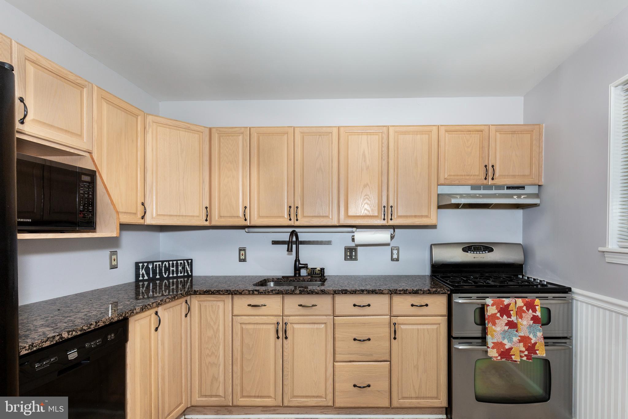 318 Bryanstone Road Reisterstown, MD 21136 - Photo 8 of 36 a kitchen with stainless steel appliances granite countertop a stove a sink and a refrigerator