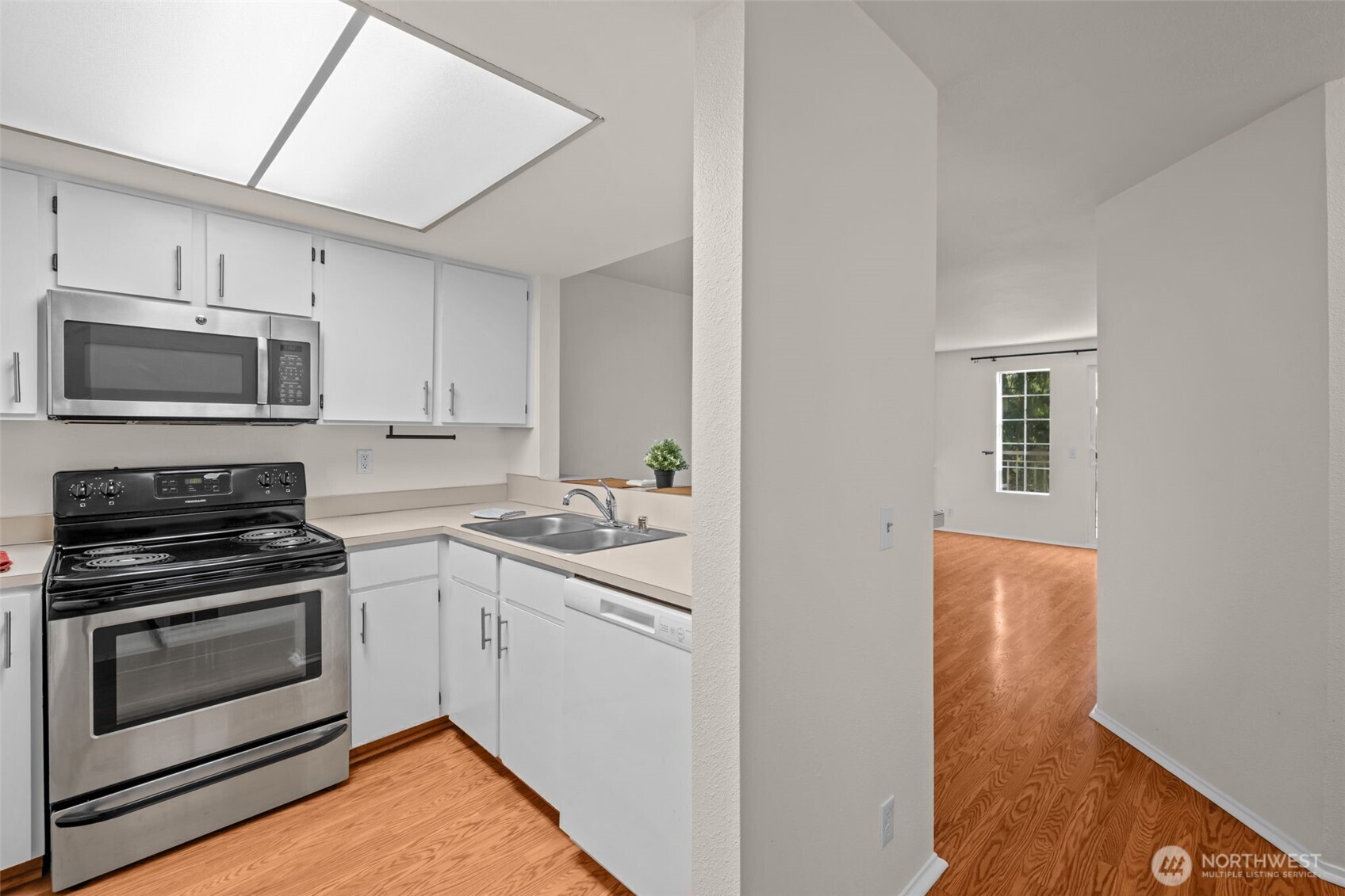 8512 242nd Street Southwest, Unit 3 Edmonds, WA 98026 - Photo 8 of 32 a kitchen with stainless steel appliances a stove microwave and sink