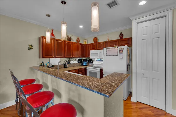 a kitchen with stainless steel appliances granite countertop a sink dishwasher and refrigerator with wooden floor